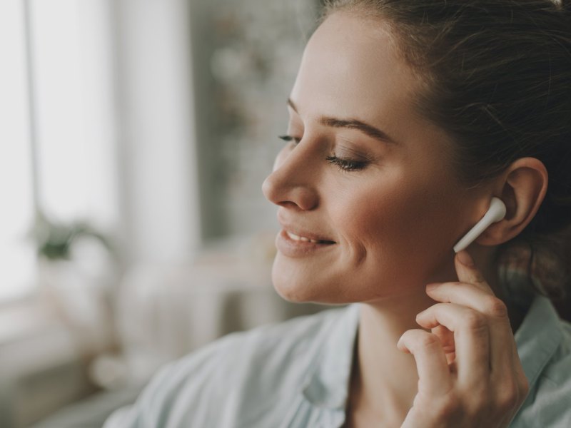 Frau mit AirPods im Ohr.