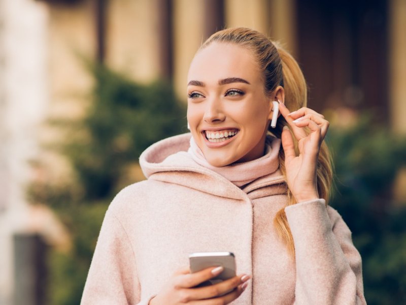 Frau mit AirPods im Ohr.