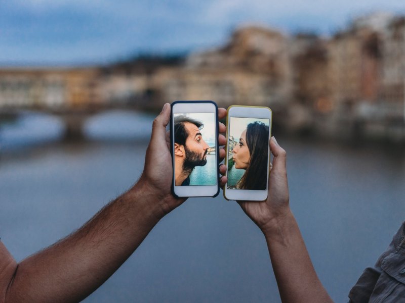 Zwei Menschen halten ihre Smartphones aneinander.