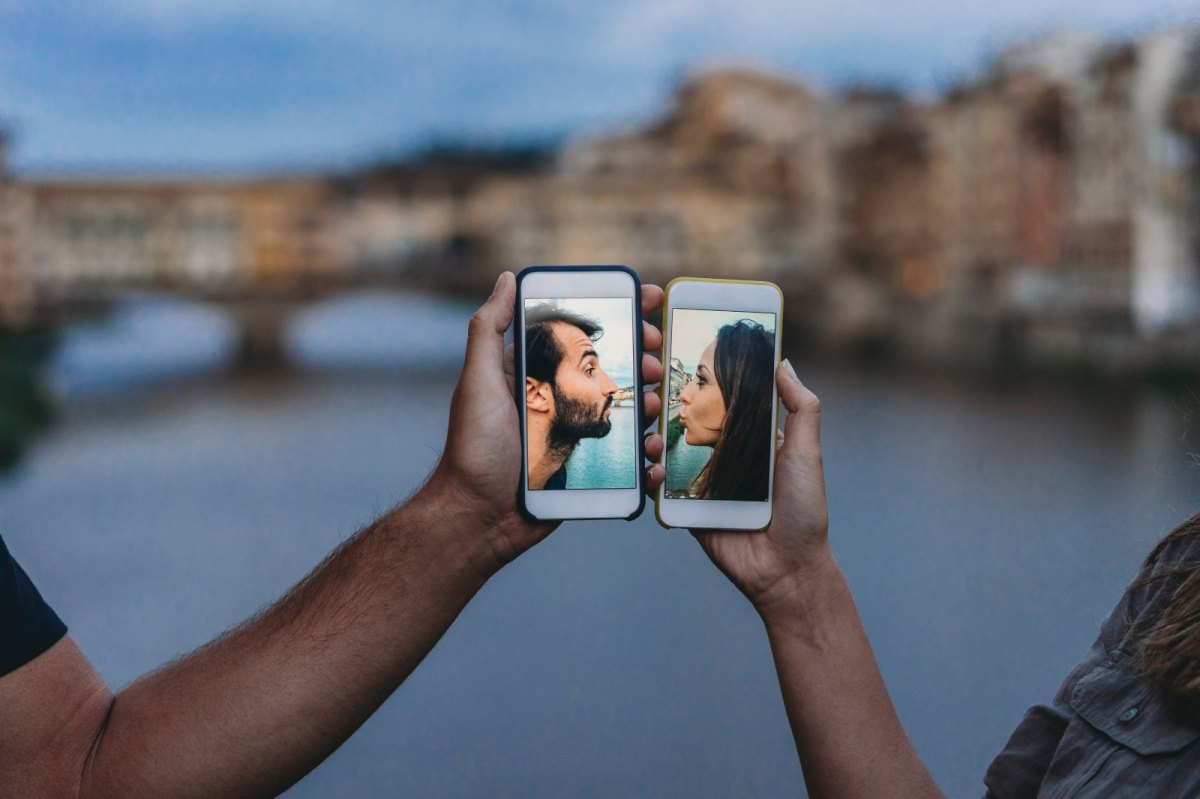 Zwei Menschen halten ihre Smartphones aneinander.