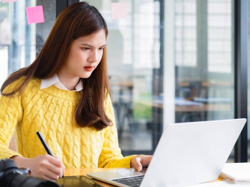 Frau arbeitet an Bildern am Laptop