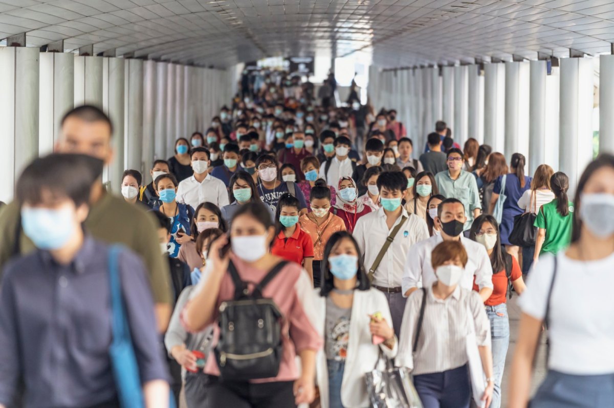 Menschen in einem Gang mit Maske.