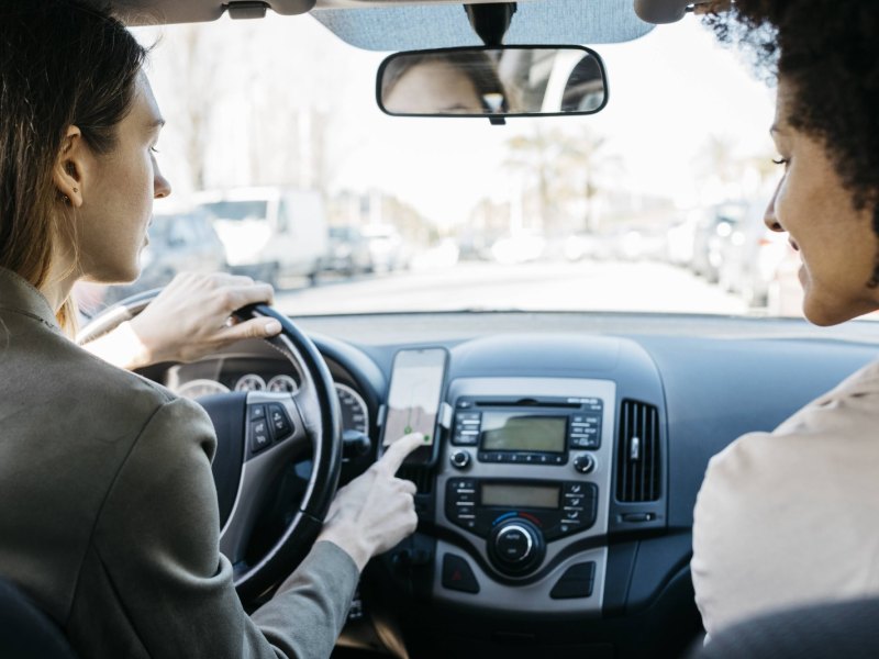 Frauen mir Smartphone im Auto