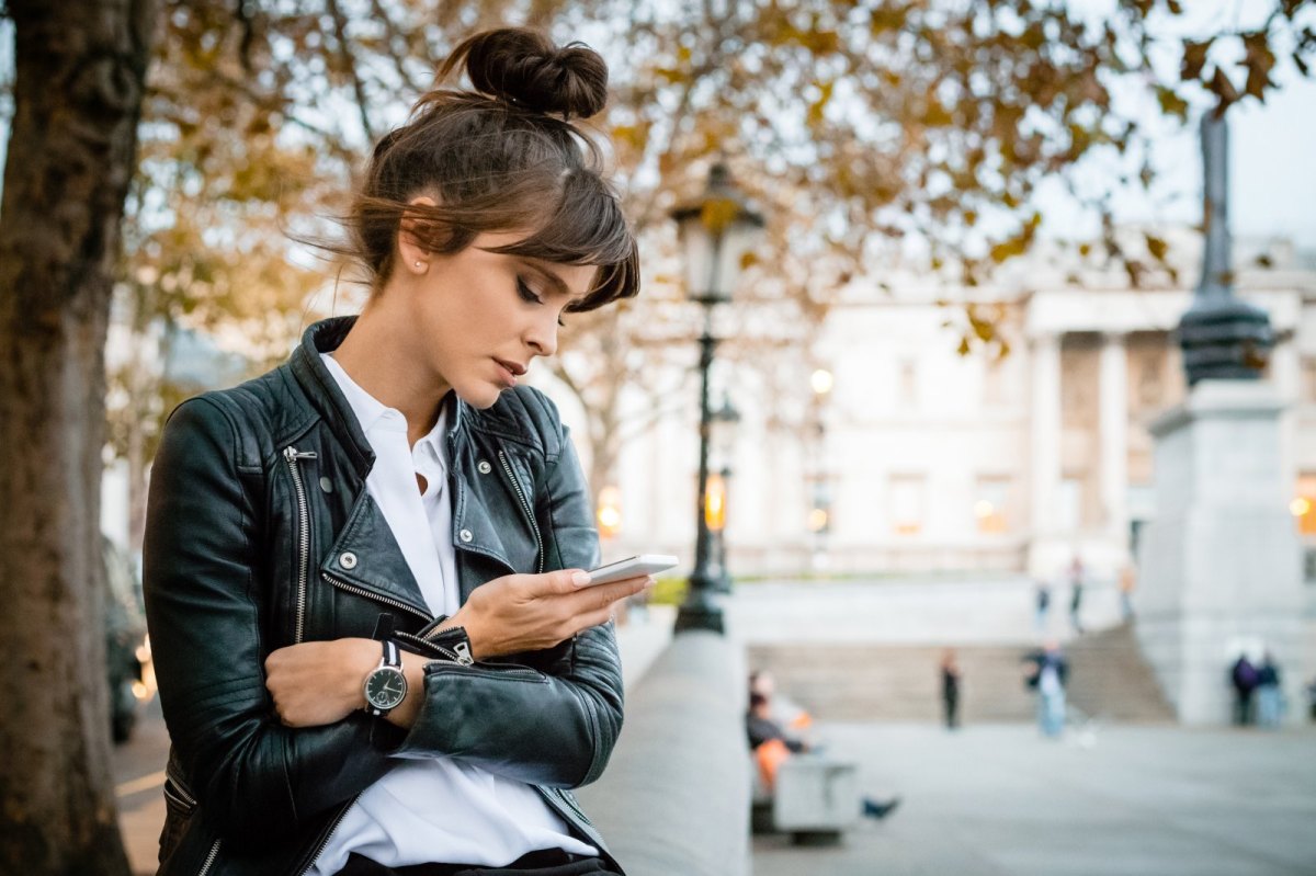 Frau schaut traurig auf ihr Handy