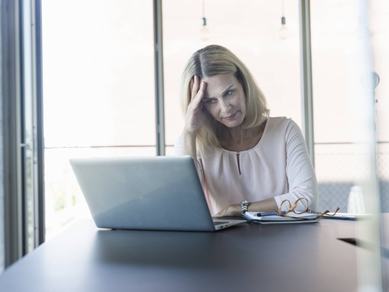 Frau guckt genervtg auf den Laptop