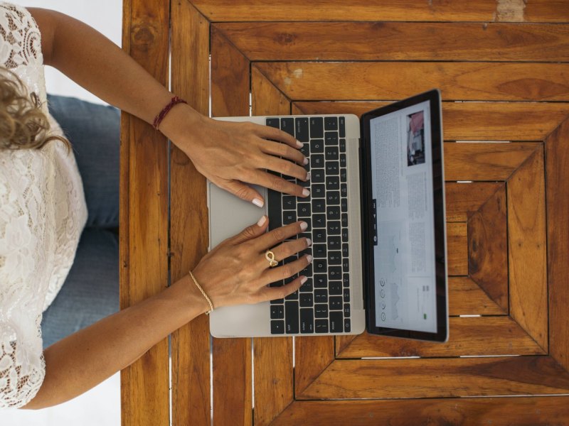 Frau tippt auf einem Laptop