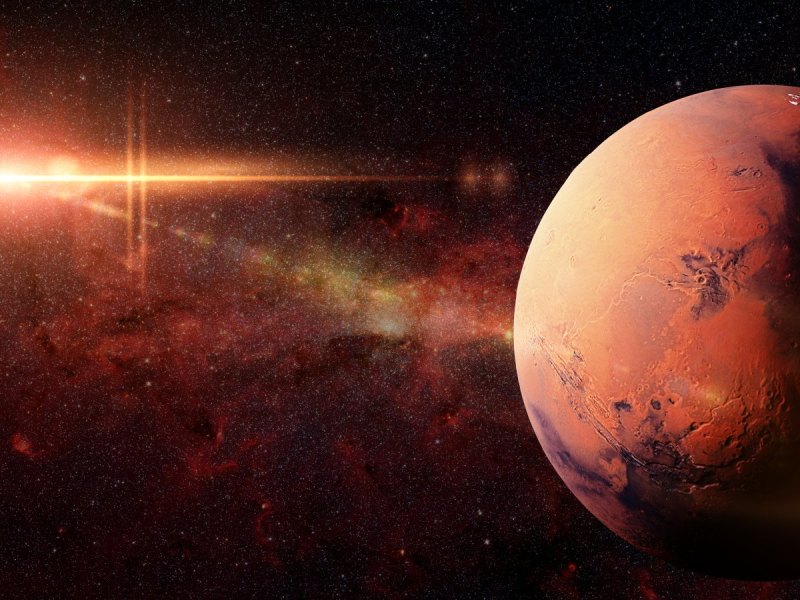 Planet Mars in der Galaxie und die Sonne im Hintergrund.