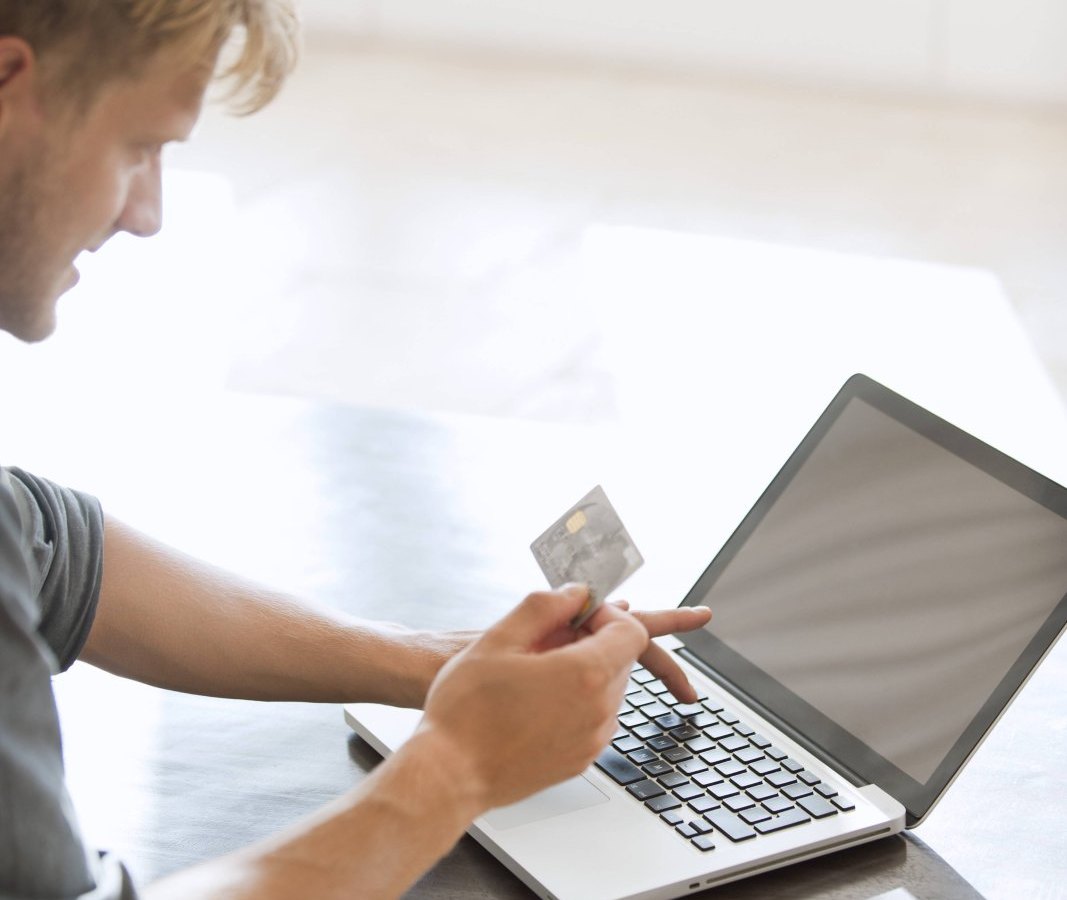 Mann mit MasterCard am Laptop