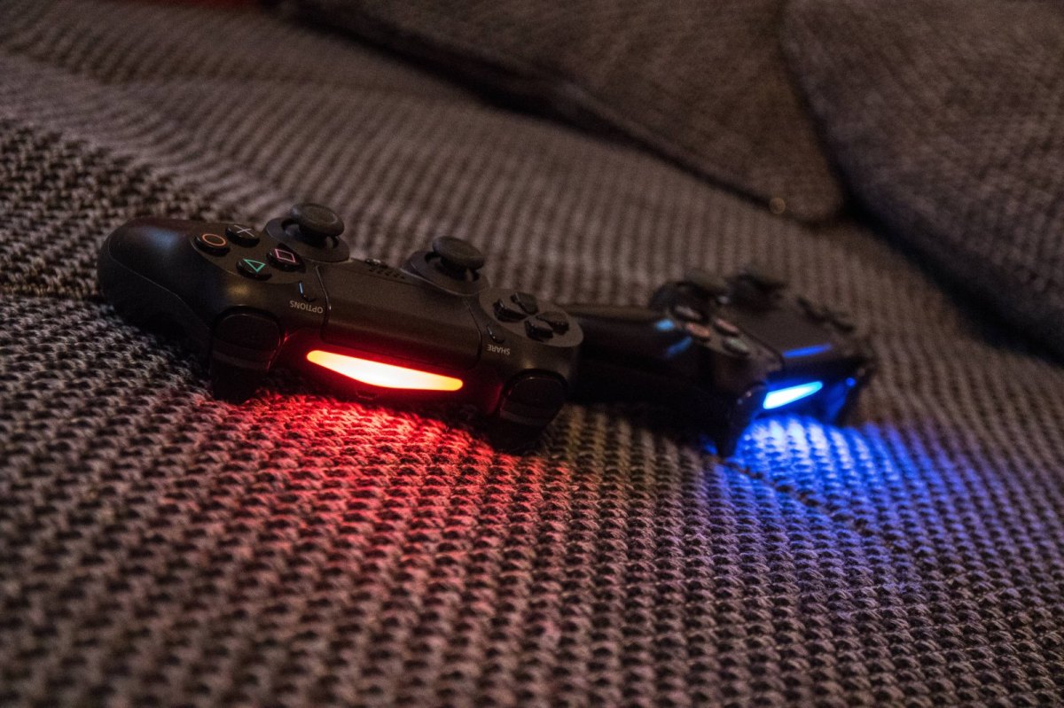 Zwei PlayStation 4 Controller auf dem Sofa.