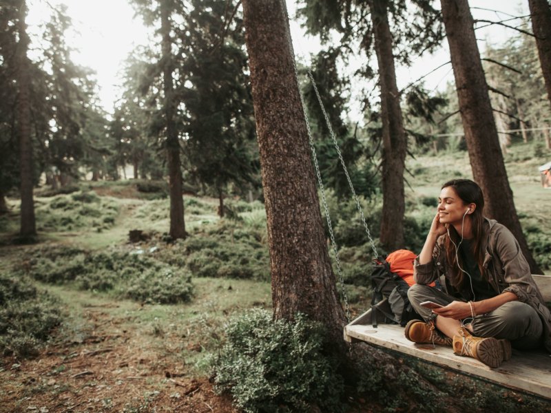 Frau mit Kopfhörern im Wald