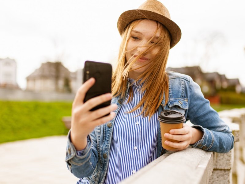 Eine Frau macht mit einem Smartphone ein Selfie.