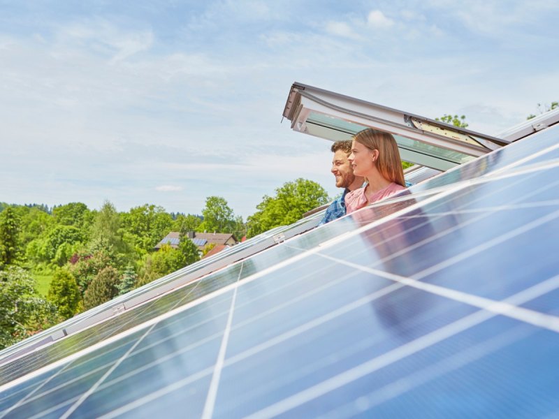 Paar schaut aus Dachfenster Solaranlagen