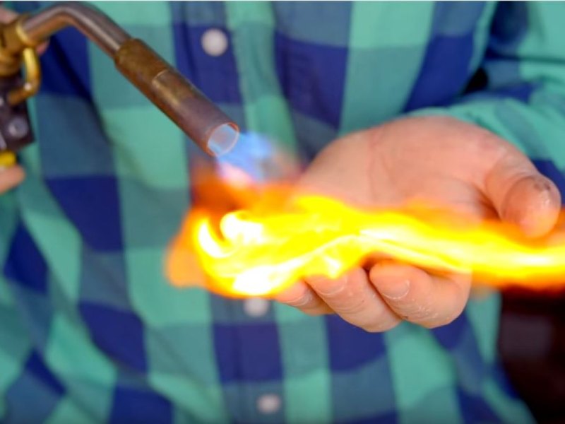 Hobby-Chemiker zündet Material auf seiner bloßen Hand an.