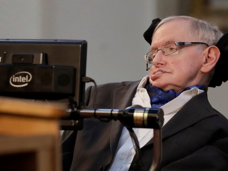 Stephen Hawking im Rollstuhl vor einem Mikrofon