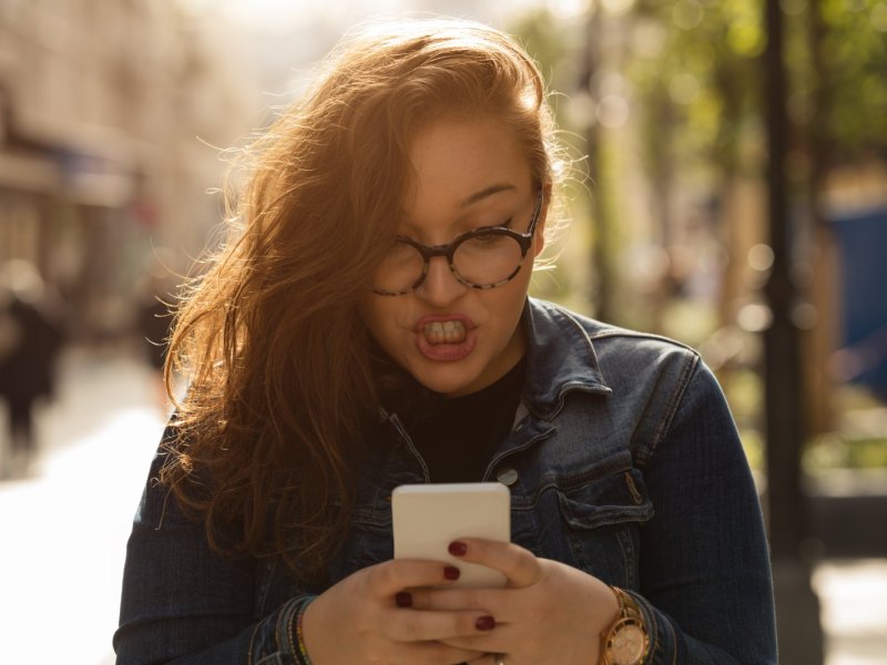 Frau tippt auf ihrem Handy.