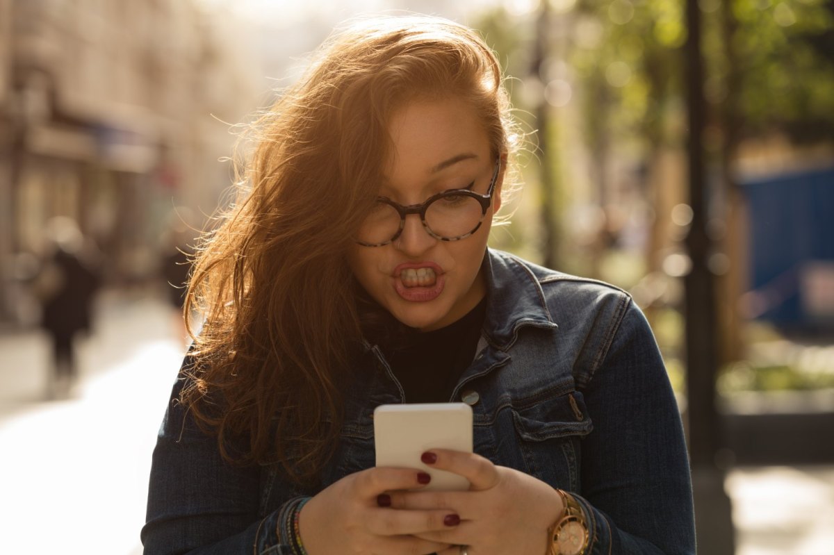 Frau tippt auf ihrem Handy.