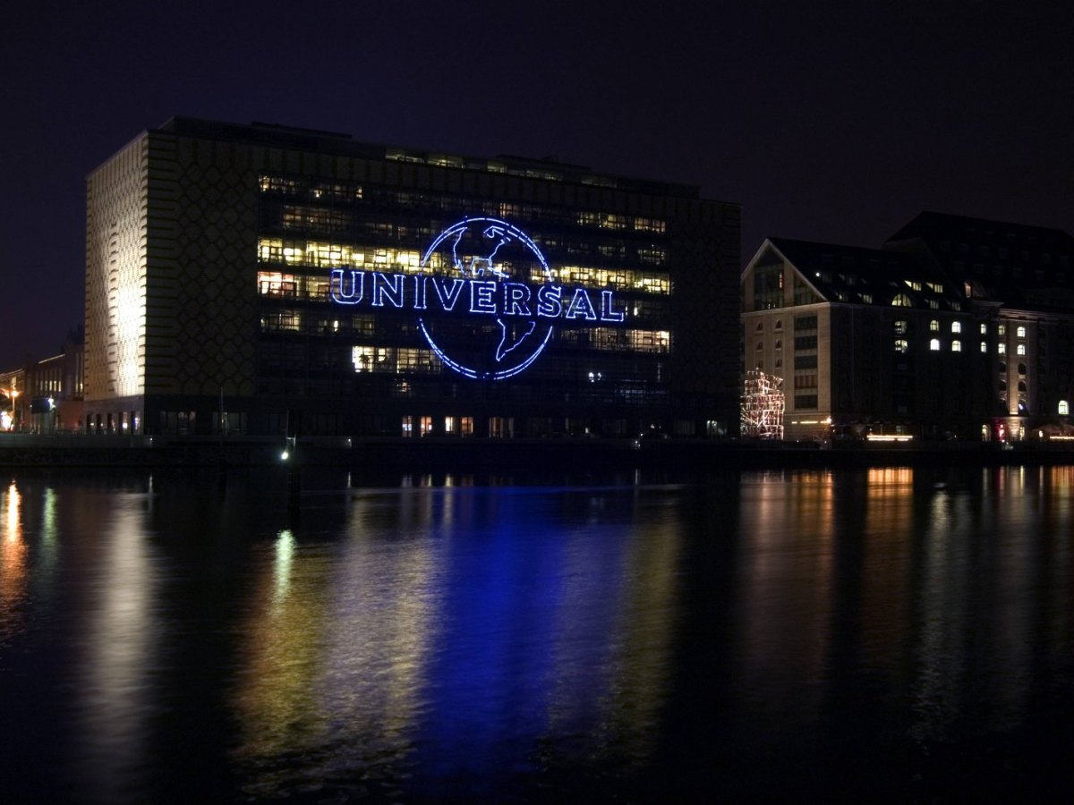 Das Universal Music Logo am Bürogebäude in Berlin leuchtet nachts.