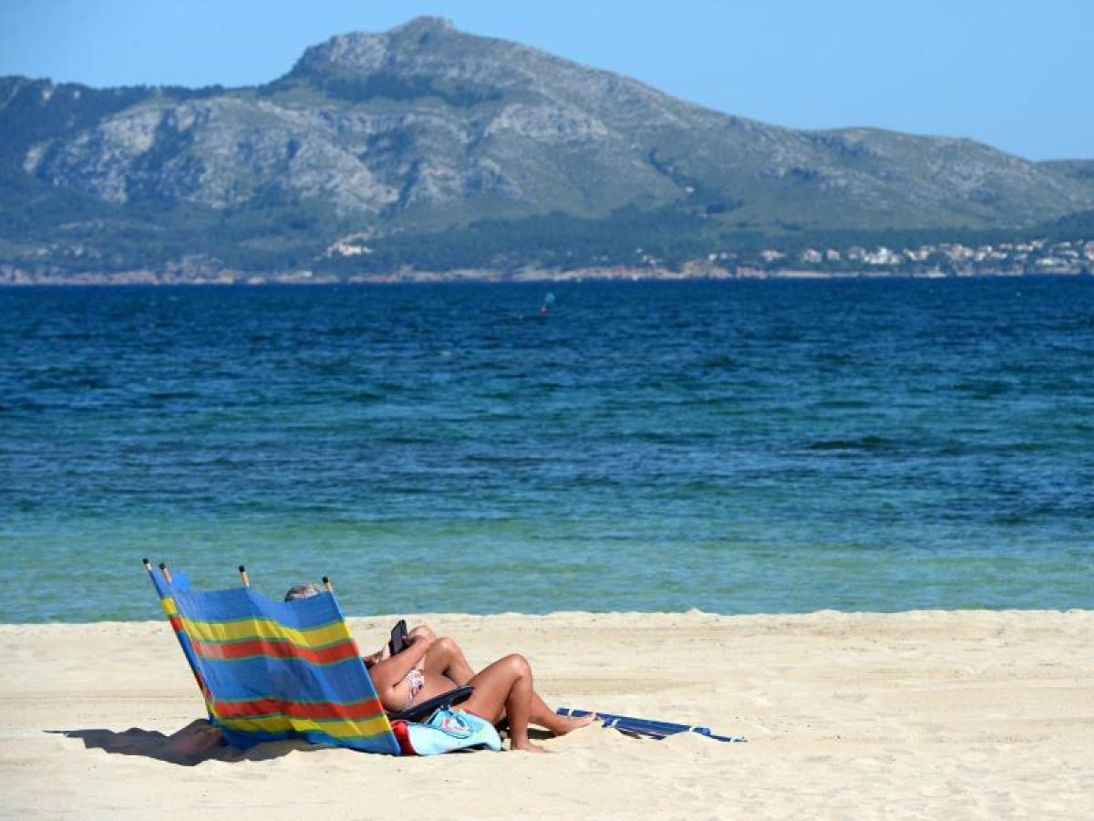 Urlauberin auf Liegestuhl am Strand