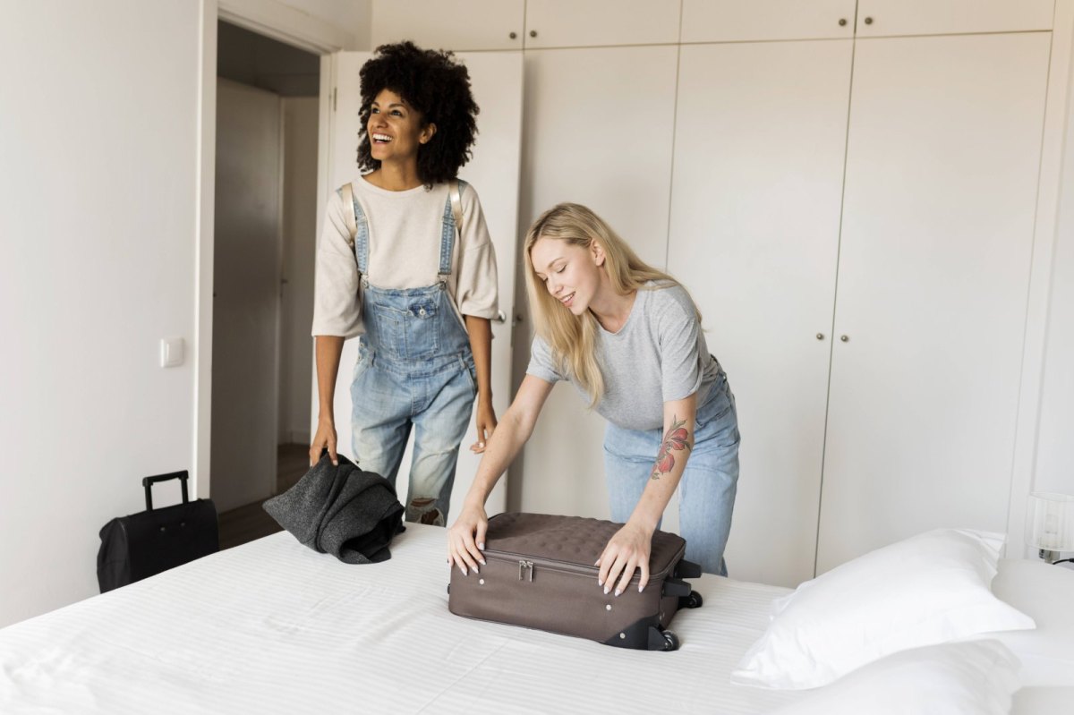 Zwei Frauen packen ihre Koffer aus.