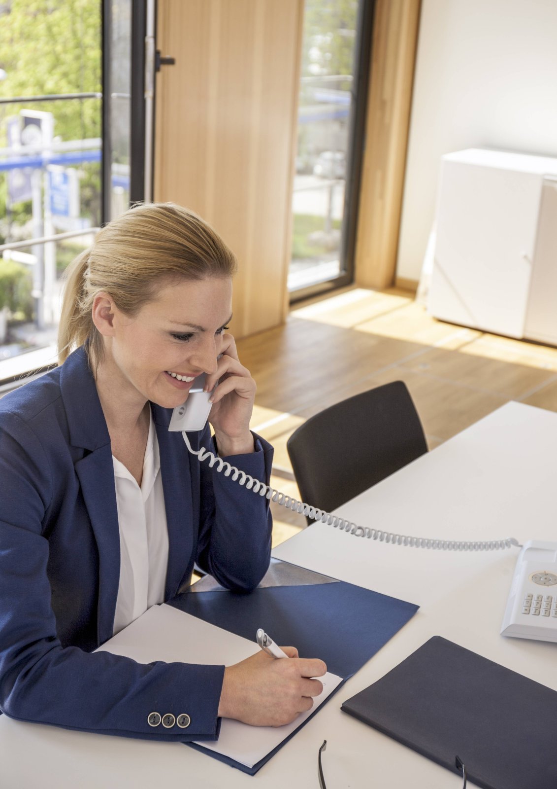 Frau beim Telefonieren am Schreibtisch