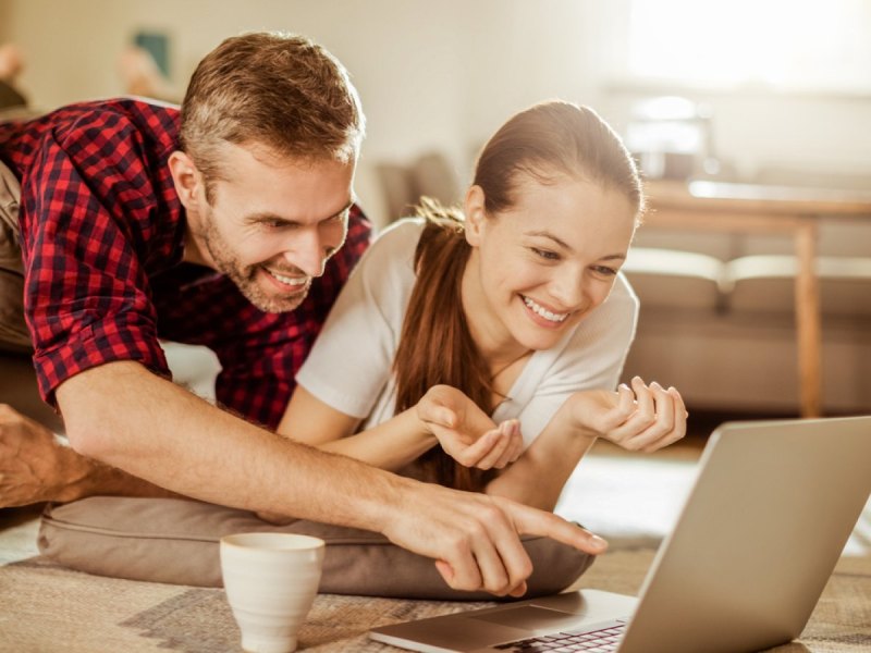 Mann und Frau glücklich am Laptop.