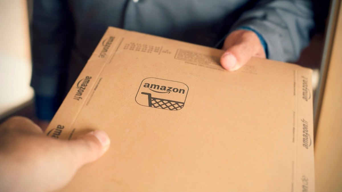 Mann hält Amazon-Paket in der Hand