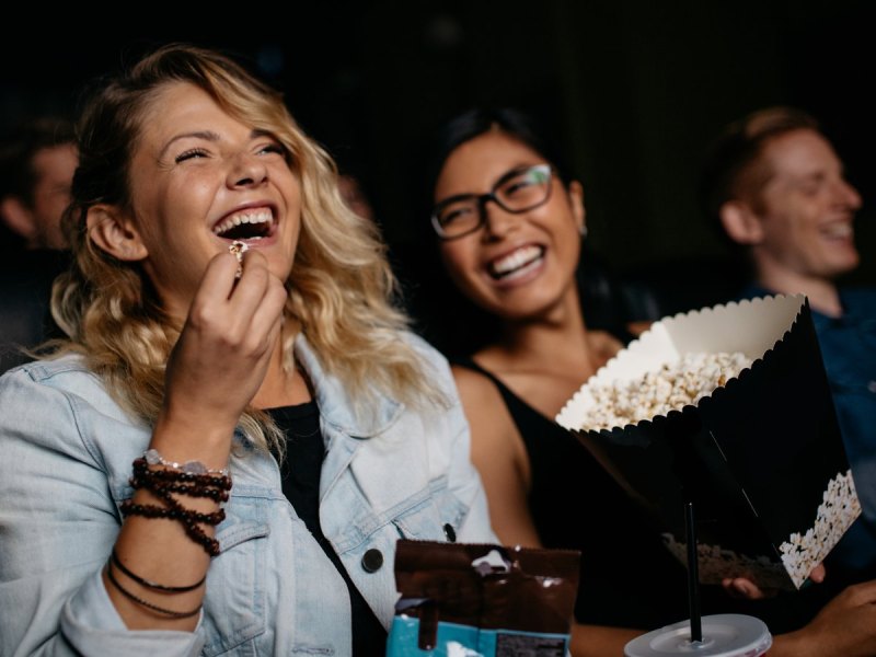 Zwei Frauen mit Popcorn lachen