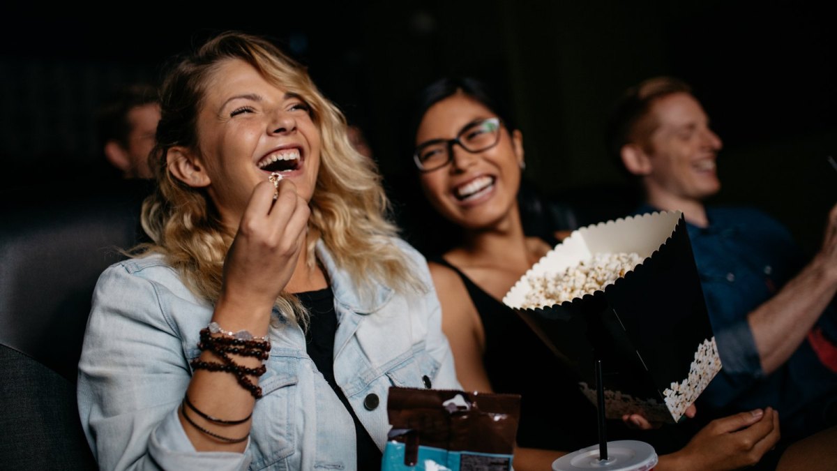 Zwei Frauen mit Popcorn lachen