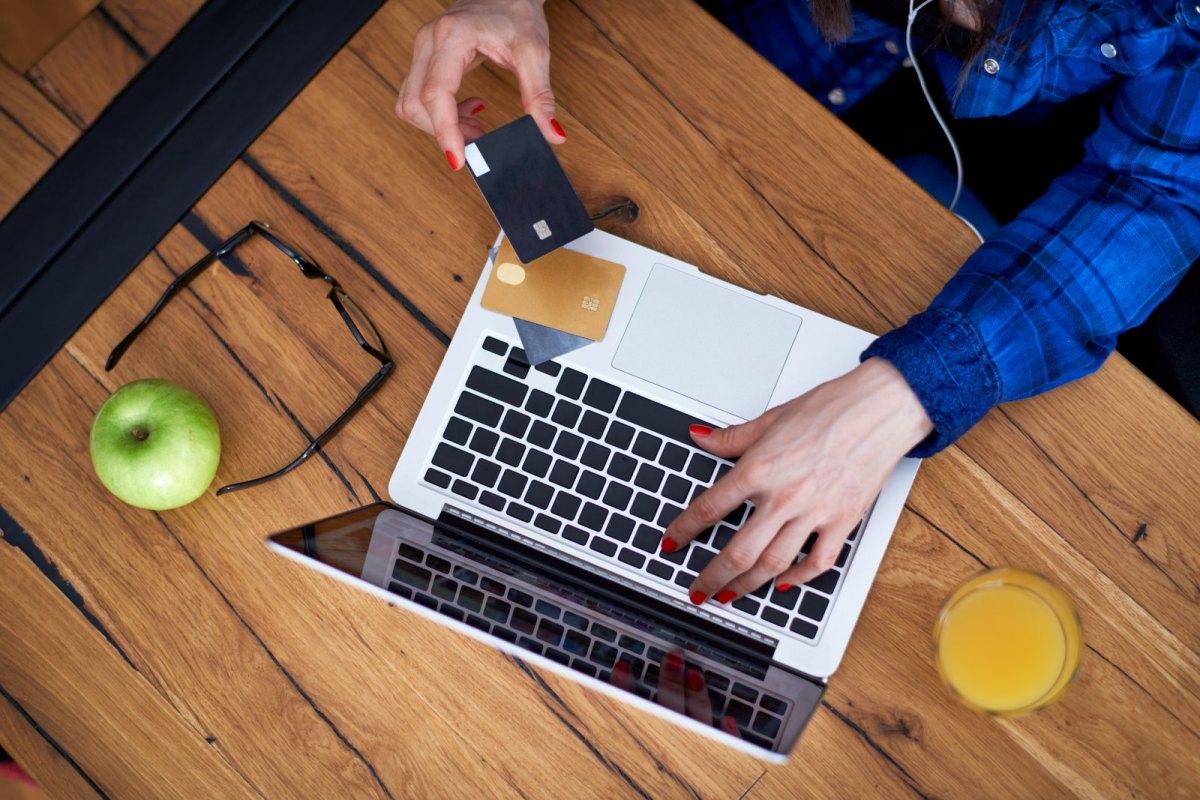 Frau mit Kreditkarten am Laptop.