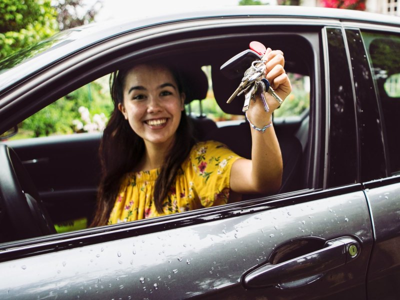 Frau freut sich über ein neues Auto