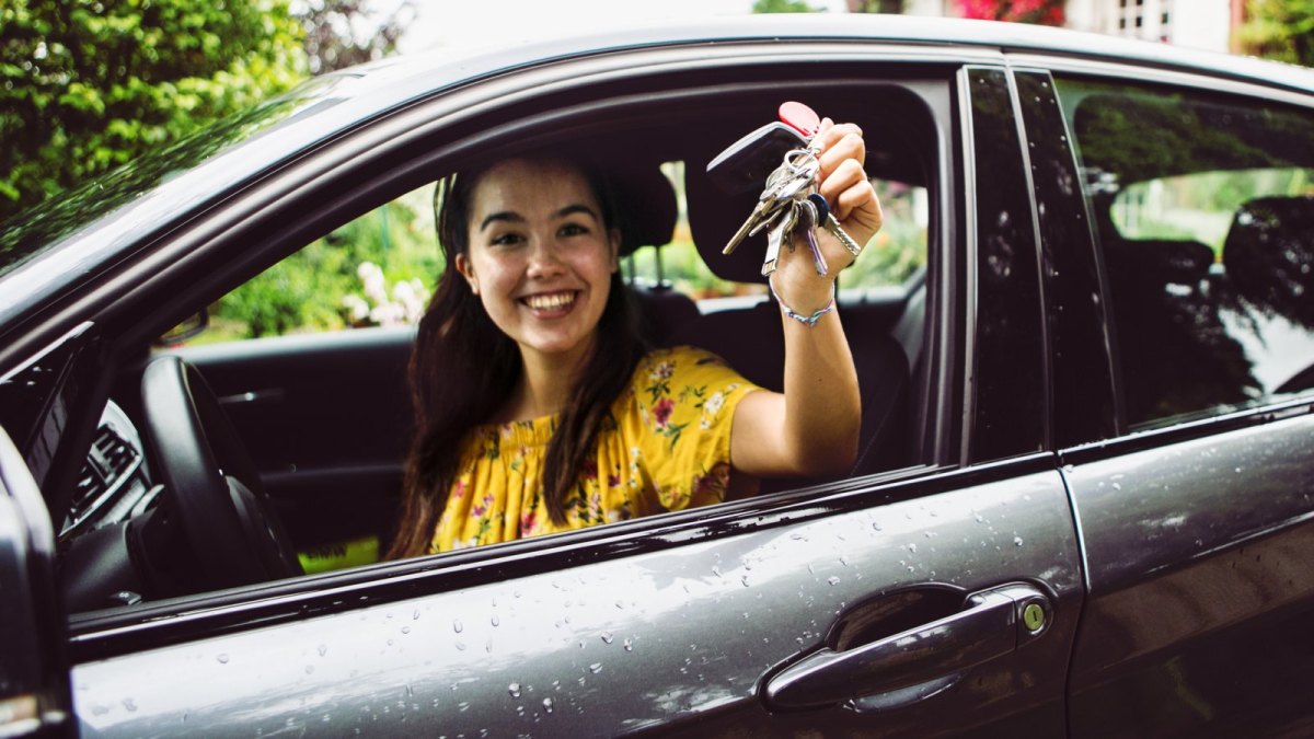 Frau freut sich über ein neues Auto