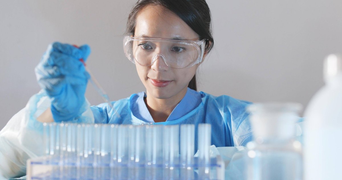 Wissenschaftlerin in einem Labor mit einer Spritze in der Hand.