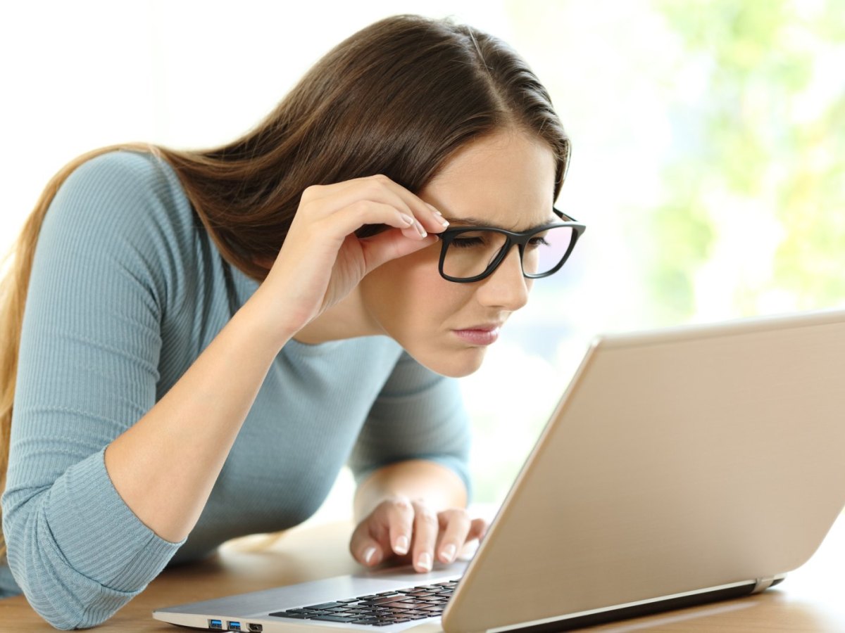 Frau schaut skeptisch auf ihren Laptop