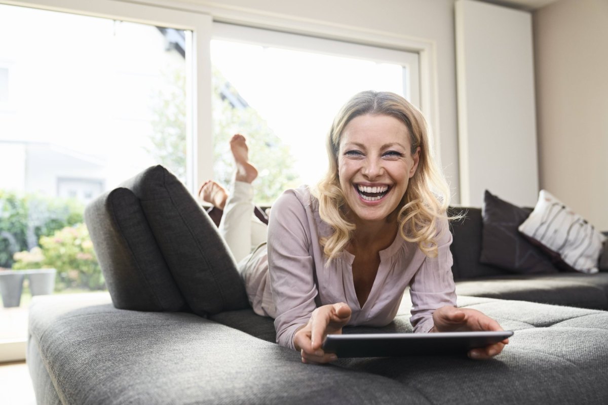 Frau am Tablet freut sich