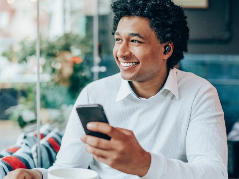 Mann mit Bluetooth-Kopfhörern.