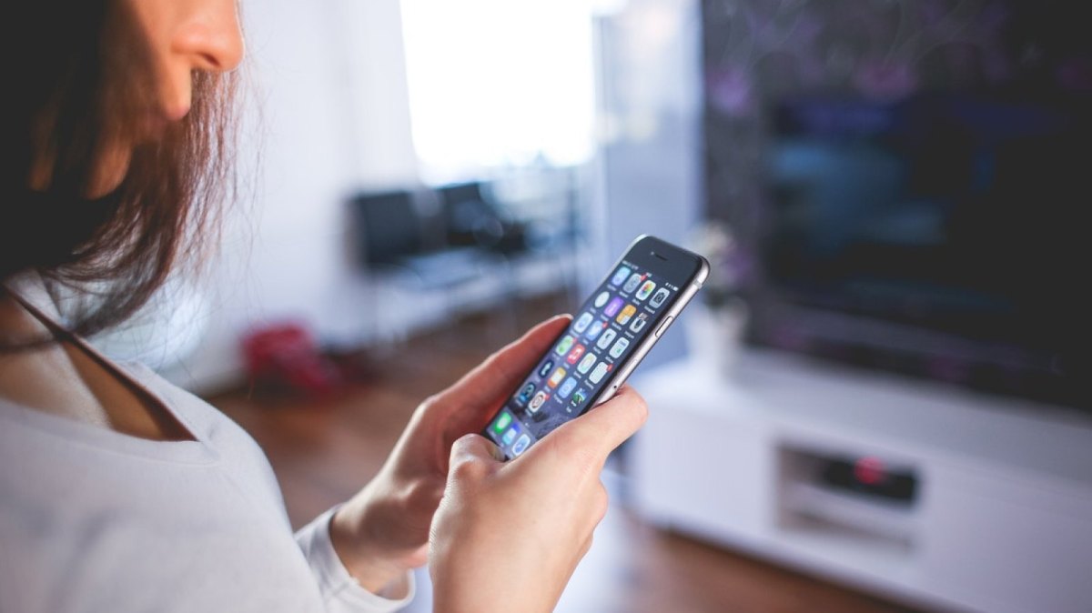 Eine Frau mit einem Smartphone in der Hand.