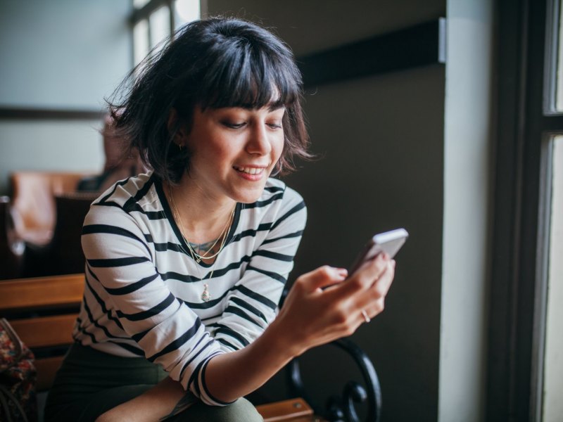 Frau guckt auf Smartphone