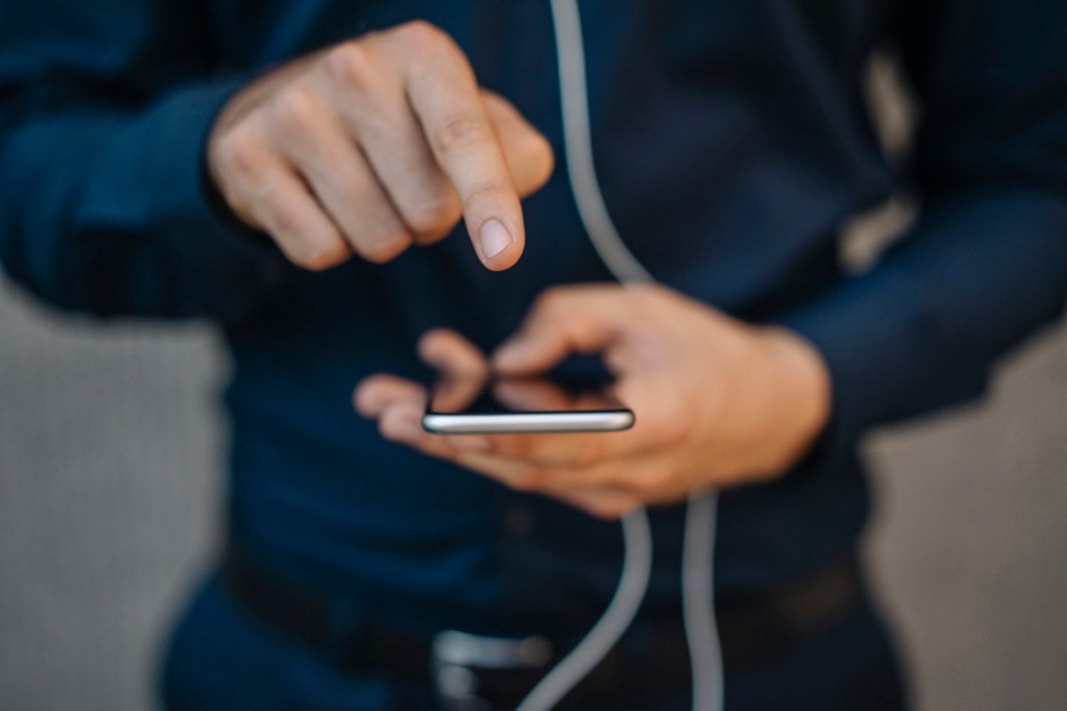 Mann zeigt mit Finger auf handydisplay