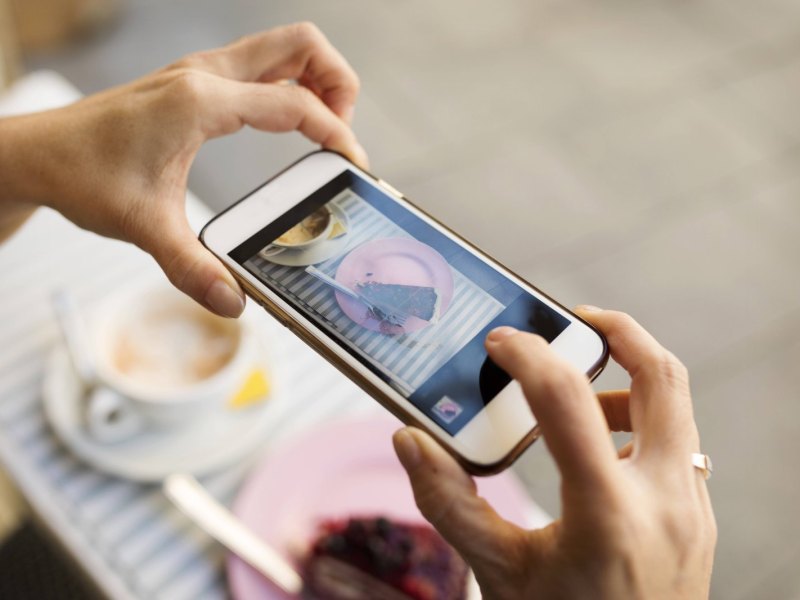 Person macht Foto von Kuchen mit dem iPhone.