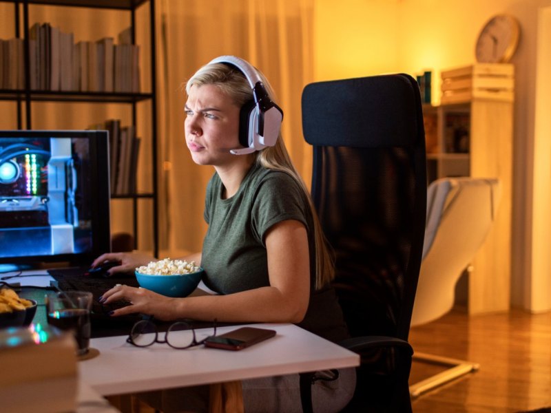 Frau sitzt vor dem PC mit Headset.