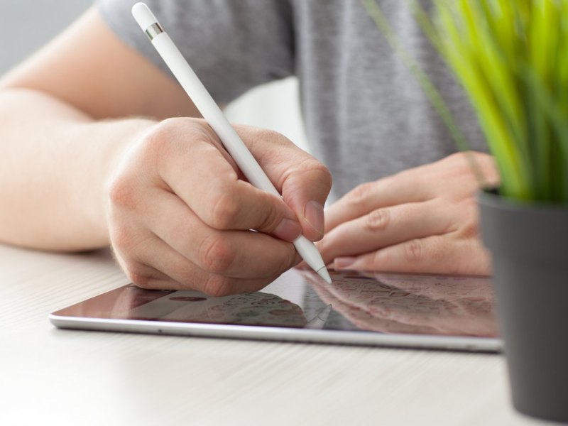 Person schreibt auf iPad