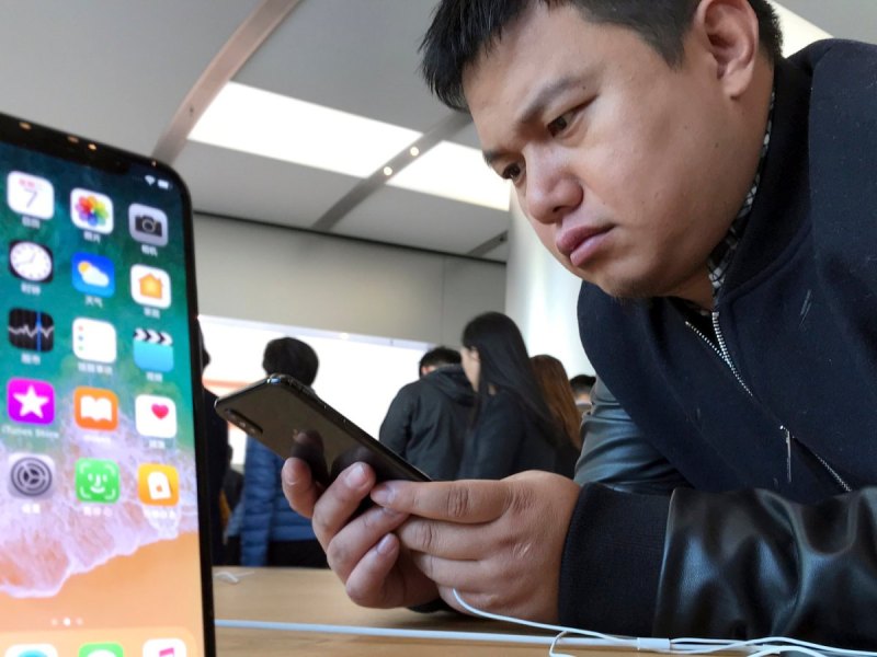 Koreanischer Mann schaut sich iPhone X im Laden an