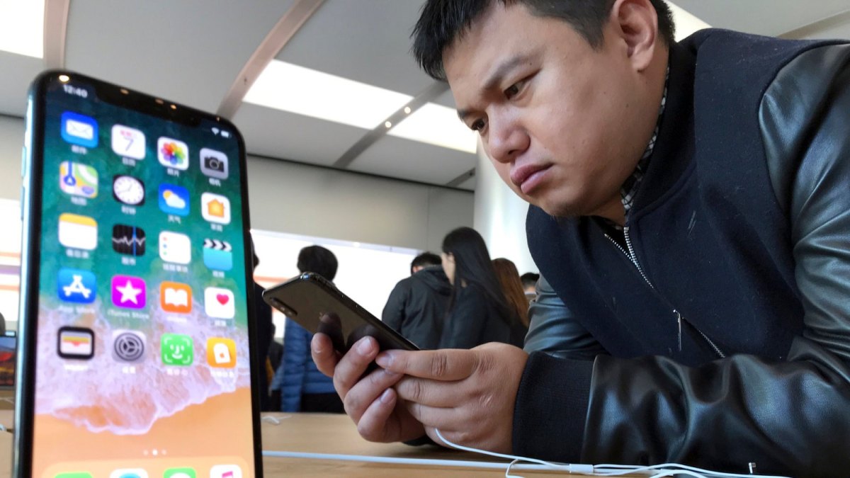 Koreanischer Mann schaut sich iPhone X im Laden an