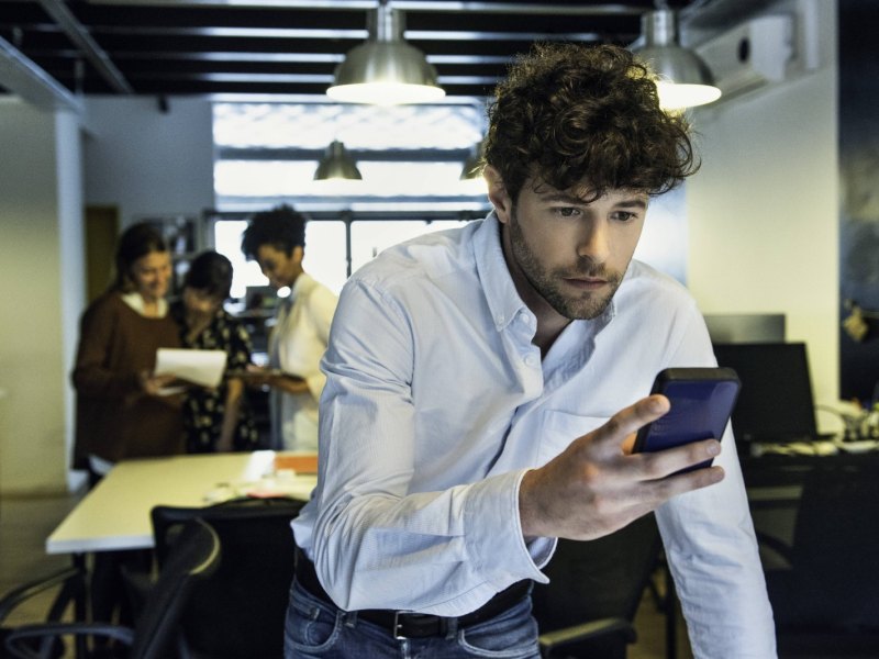 Mann starrt auf sein Smartphone