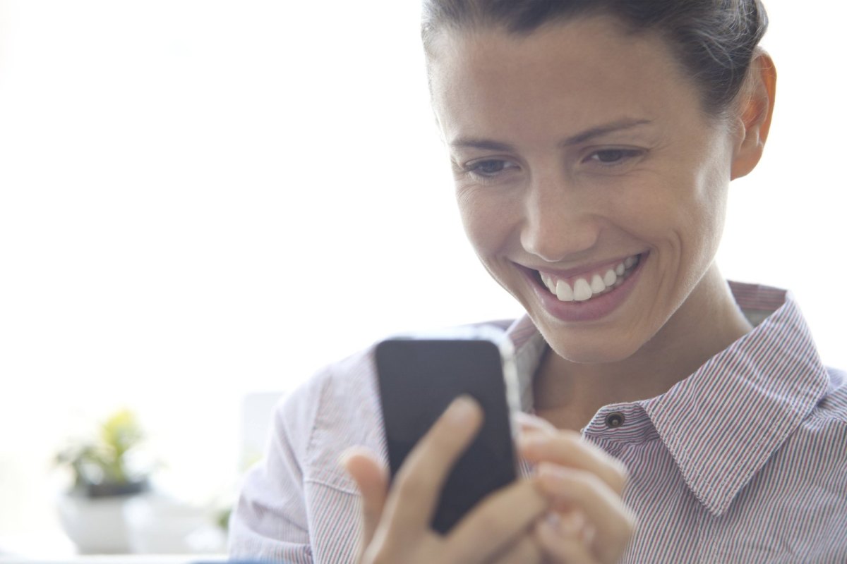 Frau mit Smartphone lacht