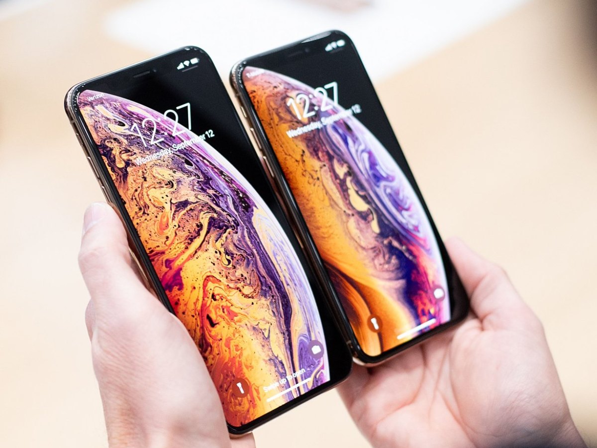 Person hält iPhone XS Max und iPhone XS nebeneinander.