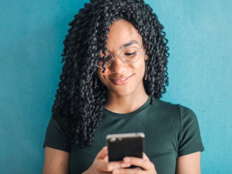 Eine Frau mit einem Smartphone in der Hand.