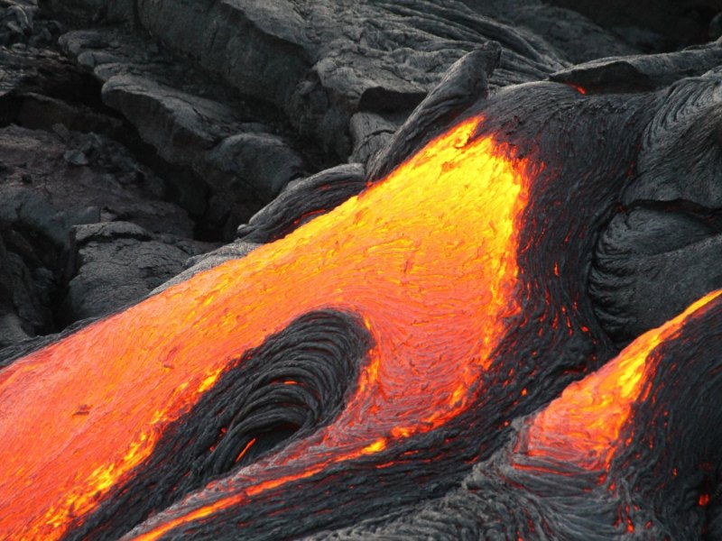 Lava fließt einen Hang herunter.