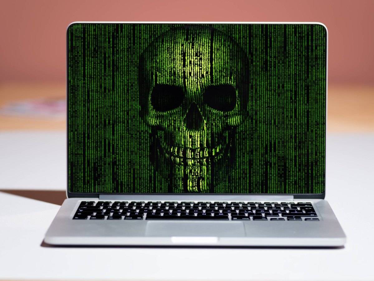 Gehacktes Apple MacBook zeigt Totenkopf auf dem Bildschirm