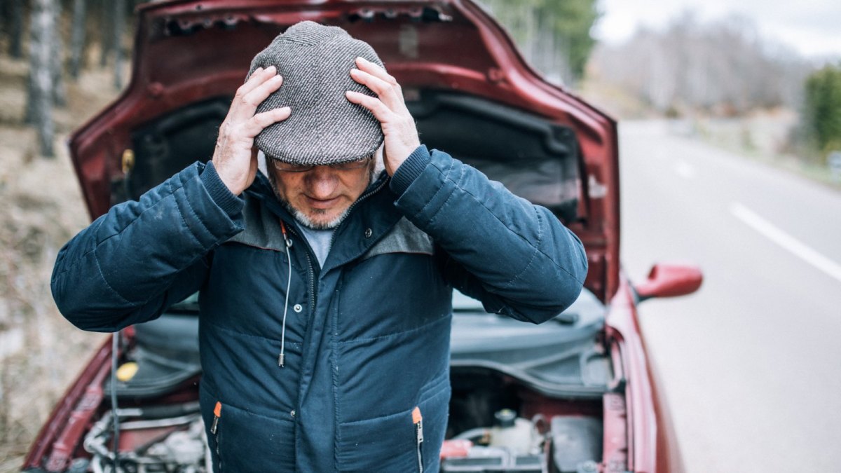 Mann vor offenem Motorraum